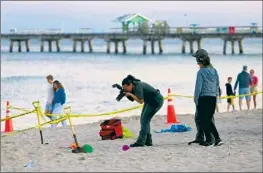  ?? Mike Stocker South Florida Sun-Sentinel ?? AN INVESTIGAT­OR takes photos at the scene of a deadly sand collapse in Lauderdale-by-the-Sea, Fla., on Tuesday. Many adults tried to dig out the victim.