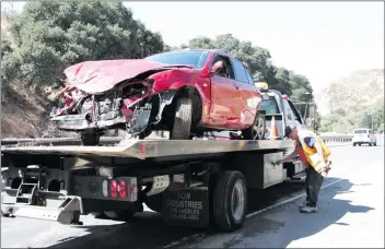  ?? Nikolas Samuels/The Signal ?? A vehicle that fell off the embankment of The Old Road near Calgrove Boulevard is put on a tow truck on Thursday.