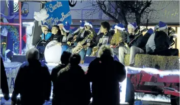  ??  ?? People watch as one of 45 floats pass by during the annual Port Colborne Santa Claus Parade Saturday night.