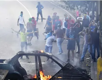  ?? YURI CORTEZ/AFP/GETTY IMAGES ?? People protest at the Cotiza Bolivarian National Guard headquarte­rs in Caracas, Venezuela, on Monday in response to the arrest of about two dozen National Guardsmen who mounted an uprising against President Nicolas Maduro.