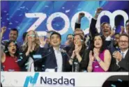  ?? MARK LENNIHAN — THE ASSOCIATED PRESS ?? Zoom CEO Eric Yuan, center, celebrates the opening bell at Nasdaq as his company holds its IPO on Thursday in New York. The videoconfe­rencing company is headquarte­red in San Jose, California.