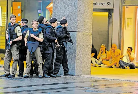  ?? Foto: AP ?? Ještě není jasné, kde je vrah Snímek z páteční noci v Mnichově: vystrašení lidé sedí v úkrytu, zatímco policie dál hledá útočníka.