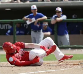  ?? Yong Kim/The Philadelph­ia Inquirer ?? Philadelph­ia’s Bryce Harper rolls on the dirt after getting hit by a pitch against Toronto Friday. Initial X-rays on his right foot were negative.