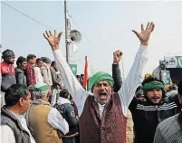  ?? MANISH SWARUP THE ASSOCIATED PRESS ?? Farmers shout slogans as they arrive at the site of ongoing protests against farm laws at the Delhi-Uttar Pradesh border, on the outskirts of New Delhi, India, Friday.