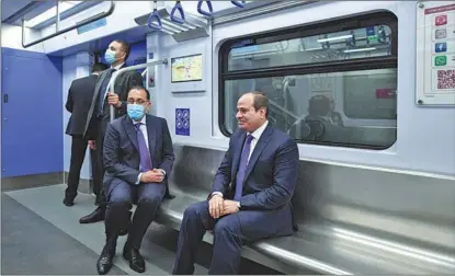  ?? EGYPTIAN PRESIDENCY / XINHUA ?? Egyptian President Abdel Fattah al-Sisi (right) and Egyptian Prime Minister Mostafa Madbouly take the first ride during the trial run of Egypt’s first electric light rail transit system on July 3 in Cairo. The system was jointly built by Chinese and Egyptian companies.