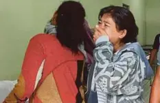  ??  ?? Dua wanita meratapi ahli keluarga mereka mati akibat minum arak buatan sendiri di sebuah hospital di Bandung, semalam. - AFP