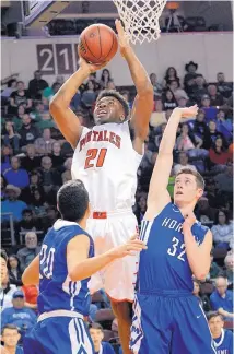  ?? JIM THOMPSON/JOURNAL ?? Portales’ Jeremie Karngbaye goes to the basket against Adam Tupler (32) and Jevon Montoya (20) of St. Michael’s. The Rams held off the Horsemen 49-47.