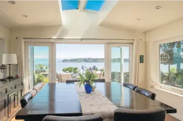  ??  ?? French doors in the family room open onto a terrace. Windows on three sides bathe the room in light along with three-metre-long double skylights in a miniature cathedral ceiling.