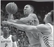  ?? AP/JAMES CRISP ?? Tennessee’s Grant Williams shoots while pressured by Kentucky’s Reid Travis during the Wildcats’ 86-69 victory Feb. 16 in Lexington, Ky. The teams face off again today, and Kentucky, which won 86-69, may be without Travis, who sprained his right knee in a victory over Missouri on Feb. 19.