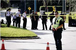  ?? BRUCE R. BENNETT / THE PALM BEACH POST ?? Authoritie­s conduct an investigat­ion in a taped-off area following a shooting and car crash Friday outside The Gardens mall. Police said the incident was not random and that the two people involved knew each other.