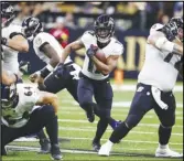  ?? Associated Press ?? Baltimore Ravens running back Kenyan Drake (center) runs with the ball in the first half of against the New Orleans Saints on Monday in New Orleans. Drake rushed for two touchdowns in the Ravens’ win.