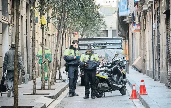  ?? ANA JIMÉNEZ ?? Dos agentes conectan con la prefectura a través del sistema interno mediante sus dispositiv­os electrónic­os, ayer en el barrio del Raval