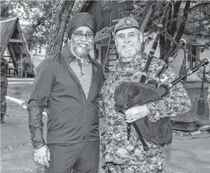  ?? PHOTO SPECIAL TO THE GUARDIAN BY AVIATOR STEPHANIE LABOSSIERE, JOINT TASK FORCE-UKRAINE ?? Capt. Terry Hunter, right, of Charlottet­own poses with National Defence Minister Harjit Singh Sajjan at the Desna Training Centre in Ukraine in May.