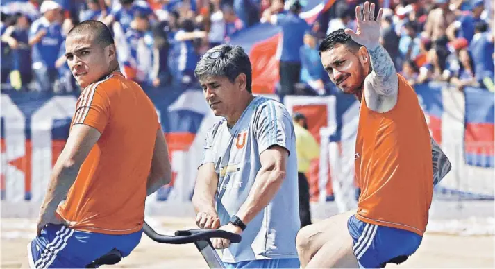  ??  ?? ►► Mauricio Pinilla realiza trabajos en bicicleta estática, junto a Leandro Benegas, en el entrenamie­nto de ayer en el Estadio Nacional.