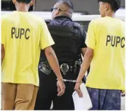  ?? ?? Handcuffed Persons under police custody are shackled together as they travel down the road towards the Metropolit­an Trial Court inside Manila City Hall on Tuesday.