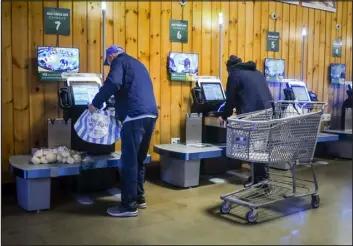  ?? BEBETO MATTHEWS — THE ASSOCIATED PRESS ?? Customers use self- checkout kiosks at Stew Leonard’s grocery store in Paramus, N. J., on Dec. 13 in New York. Self- checkout faces a reckoning of sorts just as retailers are in the midst of their busiest time of the year.