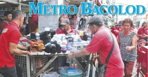  ?? ARCHIE REY ALIPALO/PN ?? City Legal Office Enforcemen­t Unit personnel move items from a stall owned by a sidewalk vendor along Luzuriaga Street in Bacolod City. Vendors are only allowed to use a 1-meter-by-1-meter area when doing business along streets, according to the City...