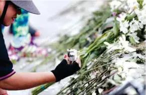 ??  ?? TRIBUTO. Ciudadanos colocan flores en homenaje a los caídos en el atentado contra la escuela policial en Bogotá. (EFE)