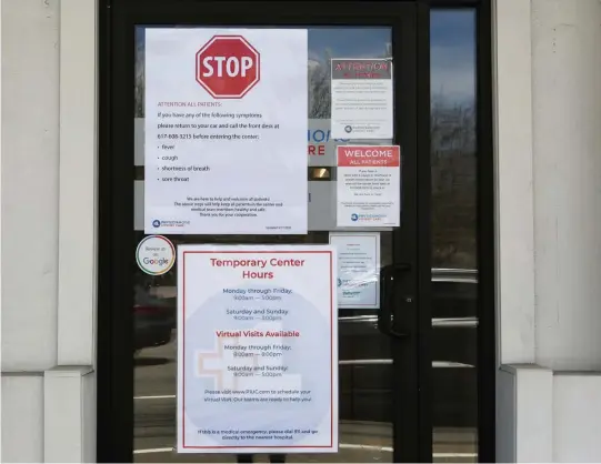  ?? ANGELA ROWLINGS / HERALD STAFF FILE ?? FROM A DISTANCE: Signs advising patients last month to call from their cars if they have coronaviru­s symptoms are seen on a Brookline urgent care facility door.