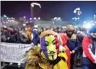  ?? DANIEL MIHAILESCU/AFP ?? A man in a mask attends a protest last week in Bucharest.