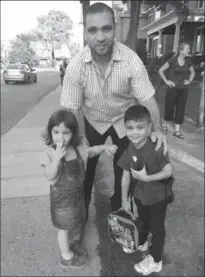  ?? SPECIAL TO THE SPECTATOR ?? Syrian refugee Mohamed Alssagher with his children Sidra and Abdullah meet the bus for the first day of school, with help from Longer Table sponsor Kim Newcombe.