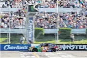  ?? [AP PHOTO] ?? Kyle Busch crosses the finish line Sunday to win the NASCAR Cup Series race at Pocono Raceway.