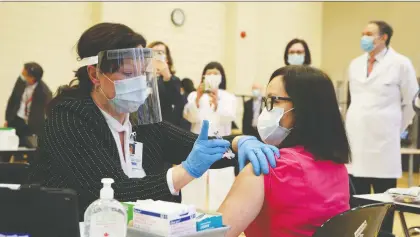  ?? CARLOS OSORIO/ REUTERS ?? Tamara Dus injects health-care worker Cecile Lasco with the Pfizer/biontech vaccine in Toronto on Monday. Because there was a problem with the needle's connection to the vial, some of the vaccine leaked out.