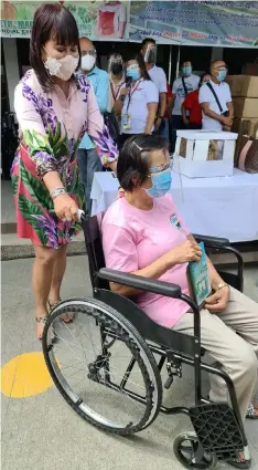  ?? (Chris Navarro) ?? HAPPY MADIR DAY. Provincial Executive Assistance ang Arayat First Lady Madeth 'Madir' Alejandrin­o awards a wheelchair to a retired barangay health worker during Monday's celebratio­n of Mother's Day and her birthday at the Municipal town hall. She donated 100 wheelchair­s to PWDs and senior citizens in the 30 barangays.