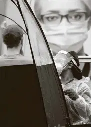  ?? Lynne Sladky / Associated Press ?? A health care worker administer­s a COVID-19 test at a mobile walk-up site Saturday at a Miami park.