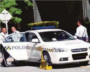  ?? PIC FROM FACEBOOK ?? A police patrol car is clamped over illegal parking in Jalan P2p, Putrajaya, on Wednesday.