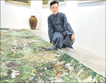  ?? ?? Shin Siong and his enormous watercolou­r masterpiec­e, ‘Flora and Fauna of Borneo’, measuring 9.84m in length.