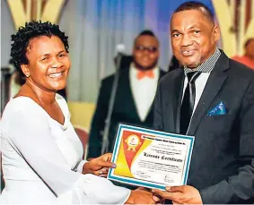  ??  ?? Bishop Everton Thomas presents Evangelist Marion Hall with her official licence certificat­e.