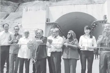  ??  ?? Pairin cutting a ribbon to mark the launch of the Sepanggar Road Tunnel yesterday.