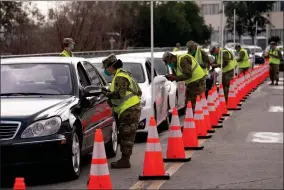  ?? AP PHOTO ?? Members of the National Guard help motorists check in at a federally-run COVID-19 vaccinatio­n site set up on the campus of California State University of Los Angeles in Los Angeles, Tuesday, Feb. 16.