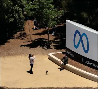  ?? JUSTIN SULLIVAN — GETTY IMAGES ?? In an aerial view, people gather in front of a sign posted at Meta headquarte­rs on July 7, 2023, in Menlo Park, California.