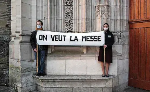  ?? Foto: AFP ?? Gläubige demonstrie­ren vor der Kathedrale Saint-Etienne in Toulouse gegen die strikten Corona-Regeln für Gottesdien­ste.