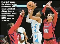  ?? ?? Deja Kelly shoots the winning basket between St. John’s guard Mimi Reid (l.) and Rayven Peeples in a firstround women’s NCAA game on Saturday.