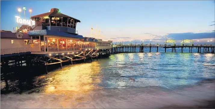  ?? Wally Skalij Los Angeles Times ?? THE TOWN’S ODDLY shaped pier anchors a lively dining and entertainm­ent district. Among the eateries there is Old Tony’s, which opened in the early 1950s.