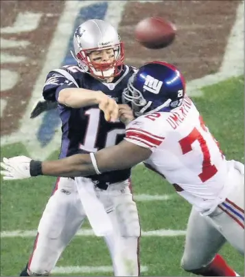  ?? By Deirdre Hamill, The (Phoenix) Arizona Republic ?? Desert heat: The Giants’ Osi Umenyiora hits Tom Brady as the Patriots quarterbac­k gets off a pass during Super Bowl XLII in February 2008 in Glendale, Ariz. New York’s defense sacked Brady five times en route to a 17-14 upset victory.