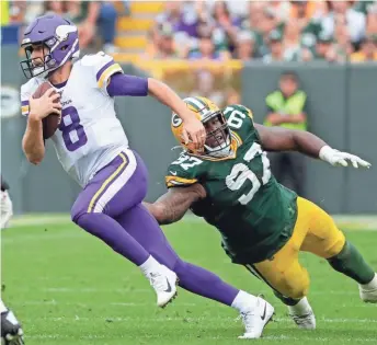  ?? JOSHUA CLARK / USA TODAY NETWORK-WIS. ?? Packers nose tackle Kenny Clark reaches to try and stop Vikings quarterbac­k Kirk Cousins during their game Sunday.