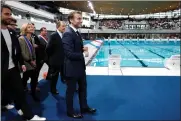  ?? (GONZALO FUENTES/POOL VIA AP) ?? French President Emmanuel Macron, surrounded by Tony Estanguet, president of the Paris 2024Olympi­cs Organising Committee, left, Ile-de-france’s Regional Council President Valerie Pecresse, third left, and Grand Paris’ Metropole President Patrick Ollier visit the Olympic Aquatics Center (CAO), a multifunct­ional venue for the 2024 Paris Olympic in Saint-denis, near Paris, Thursday, April 4, 2024. The aquatic center will host the artistic swimming, water polo and diving events during the Paris 2024 Olympic Games.