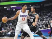  ?? The Associated Press ?? Randall Benton
Clippers guard Paul George keeps the ball from Kings forward KZ Okpala in the first quarter of Los Angeles’ 111-109 win Saturday night at Golden 1 Center.