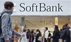  ?? — AFP ?? People walk past Softbank branch in central Tokyo.
