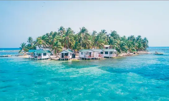  ?? DUARTE DELLAROLE/DREAMSTIME ?? Tobacco Caye is a tiny island filled with palm trees and bungalows in the Belize Barrier Reef.