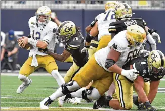  ?? HYOSUB SHIN/HYOSUB.SHIN@AJC.COM ?? Tech’s Kaleb Oliver gets to Notre Dame quarterbac­k Ian Book during the second half Saturday. The Jackets’ play — one turnover, six penalties — bettered season averages in both categories.