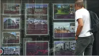  ?? ANDREW WINNING / REUTERS ?? A man looks at property for sale at an estate agency in London on Aug 4.