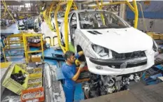  ?? ASSOCIATED PRESS FILE PHOTO ?? An Iranian worker assembles a Peugeot 206 at the state-run Iran-Khodro automobile manufactur­ing plant near Tehran, Iran.