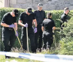  ??  ?? PAINSTAKIN­G SEARCH Officers scouring bushes and undergrowt­h