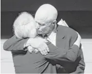  ??  ?? David Glenn hugs his sister, Carolyn Ann, after they spoke at their father’s service. Their parents were married for 73 years.