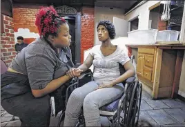  ??  ?? Sister-in-law Melissa Dixon talks to Dranell Guinn while Christophe­r, who stayed by his wife during her hospital stay, gets his first haircut in weeks at Down to Earth Barber Shop on Main Street.